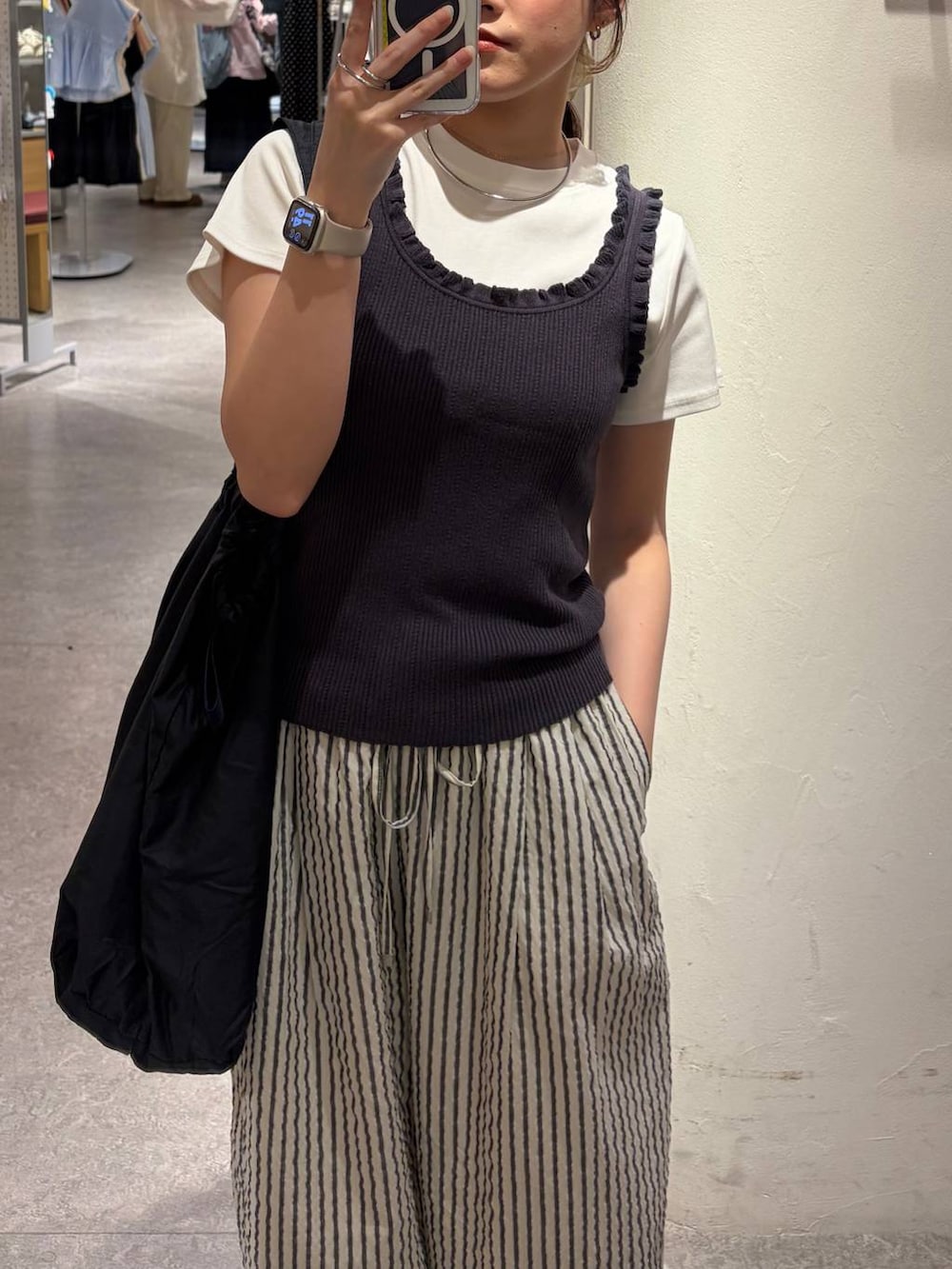 ホワイト系のTシャツ/カットソー、グレー系のタンクトップ、ブラック系のショルダーバッグを着用したレディースの春コーディネートの4枚目の写真