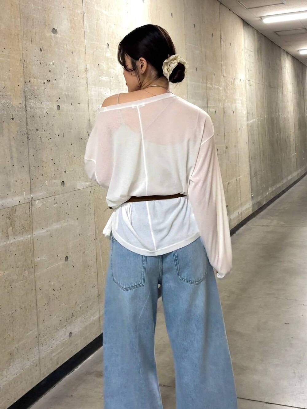 ホワイト系のTシャツ/カットソー、ブルー系のデニムパンツ、ブラック系のサンダルを着用したレディースの春コーディネートの5枚目の写真