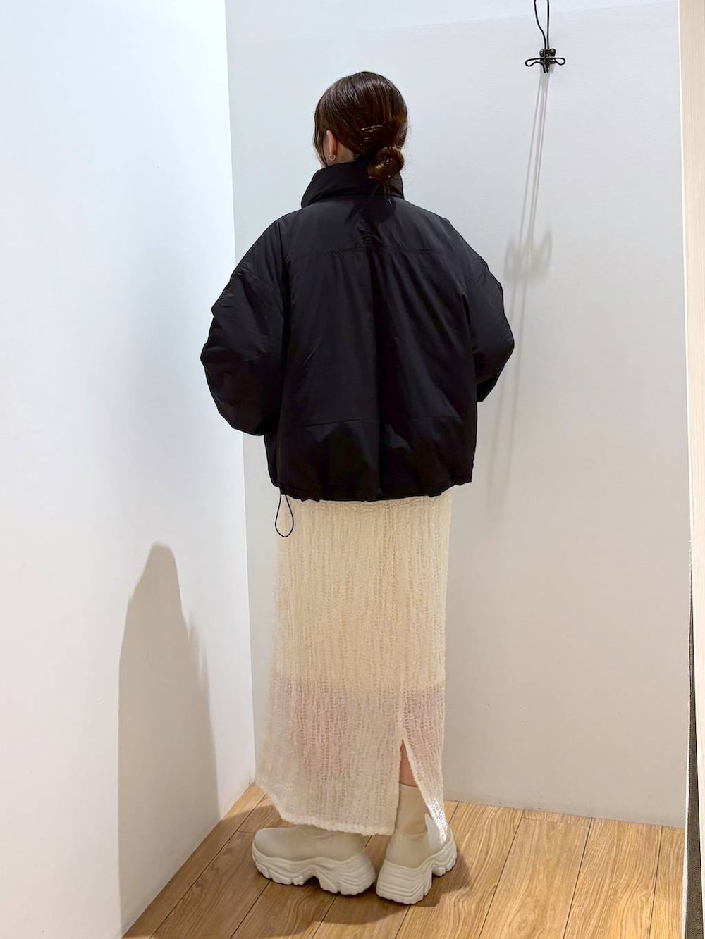 レッド系のニット/セーター、ブラック系のその他アウター、ホワイト系のブーツを着用したレディースの秋コーディネートの4枚目の写真