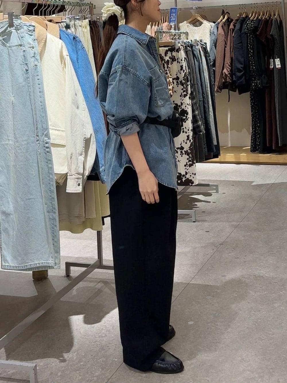 ブラック系のスウェットパンツ、ブルー系のシャツ/ブラウス、ブラック系のボディバッグ/ウエストポーチを着用したレディースの春コーディネートの2枚目の写真