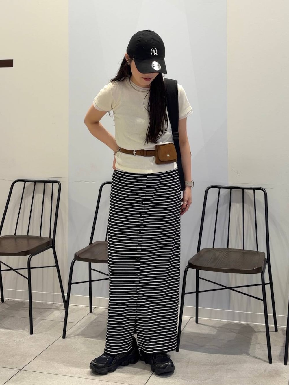 ブラック系のバックパック/リュック、ホワイト系のTシャツ/カットソー、ブラック系のスカートを着用したレディースの夏コーディネートの4枚目の写真
