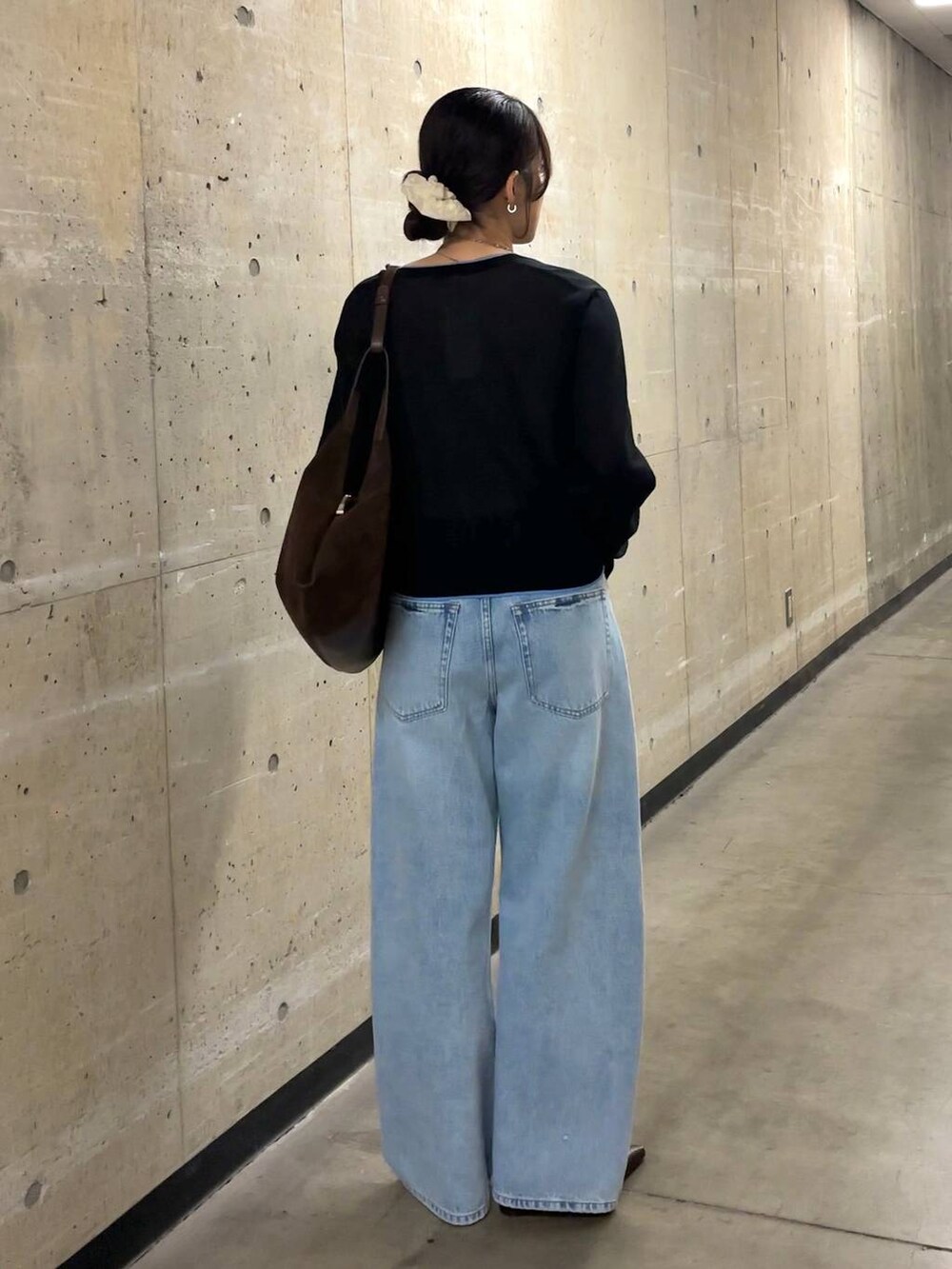 ブルー系のデニムパンツ、ブラウン系のショルダーバッグ、ブラック系のカーディガン/ボレロを着用したレディースの春コーディネートの3枚目の写真