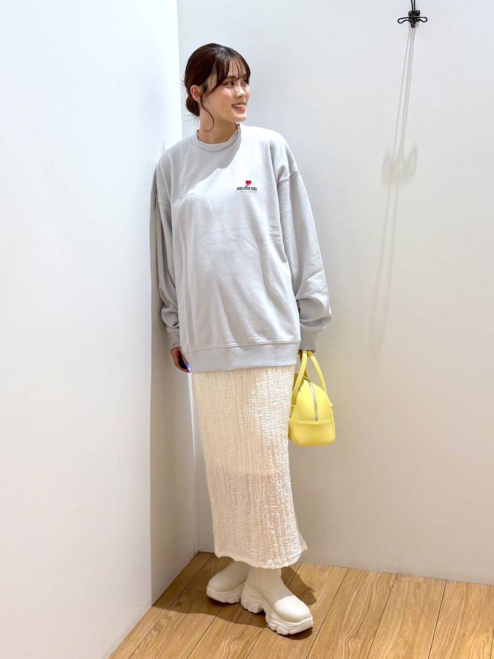 ホワイト系のブーツ、イエロー系のボストンバッグ、グレー系のTシャツ/カットソーを着用したレディースの秋コーディネートの4枚目の写真