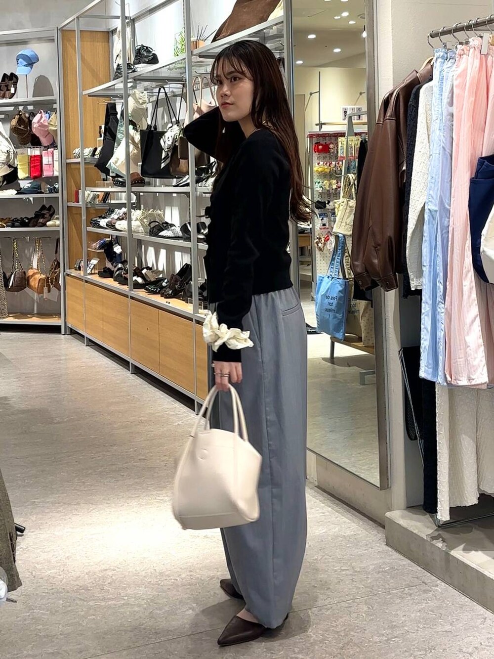 グレー系のその他パンツ、ホワイト系のショルダーバッグ、ブラック系のカーディガン/ボレロを着用したレディースの春コーディネートの2枚目の写真