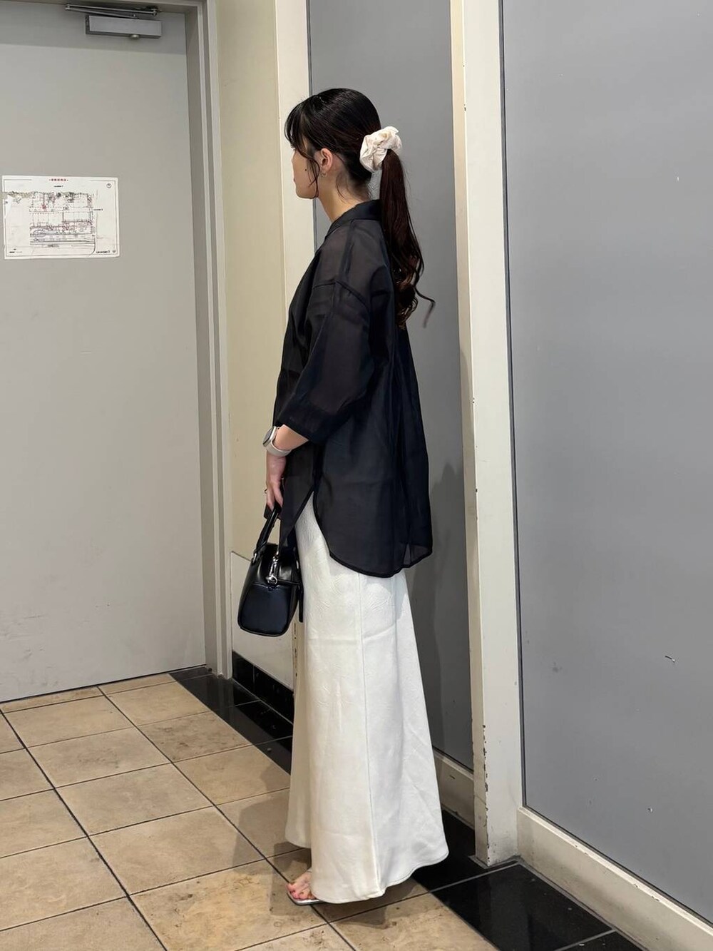 ホワイト系のスカート、シルバー系のサンダル、ブラック系のシャツ/ブラウスを着用したレディースの夏コーディネートの3枚目の写真