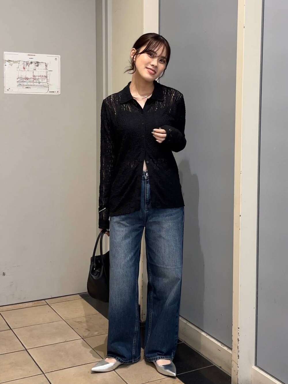 ブルー系のデニムパンツ、ブラック系のショルダーバッグ、ブラック系のキャミソールを着用したレディースの秋コーディネートの4枚目の写真