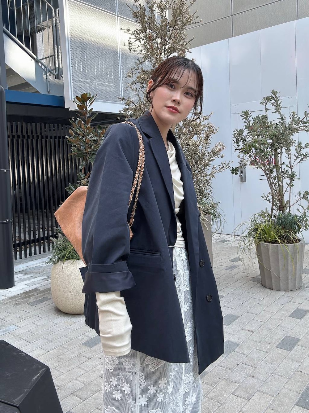 ブラック系のローファー、ベージュ系のショルダーバッグ、ブルー系のデニムパンツを着用したレディースの冬コーディネートの2枚目の写真