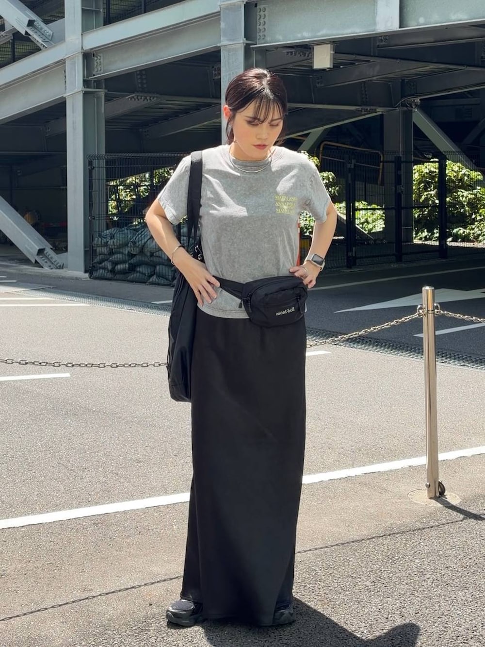 ブラック系のスカート、ブラック系のショルダーバッグ、グレー系のTシャツ/カットソーを着用したレディースの春コーディネートの4枚目の写真