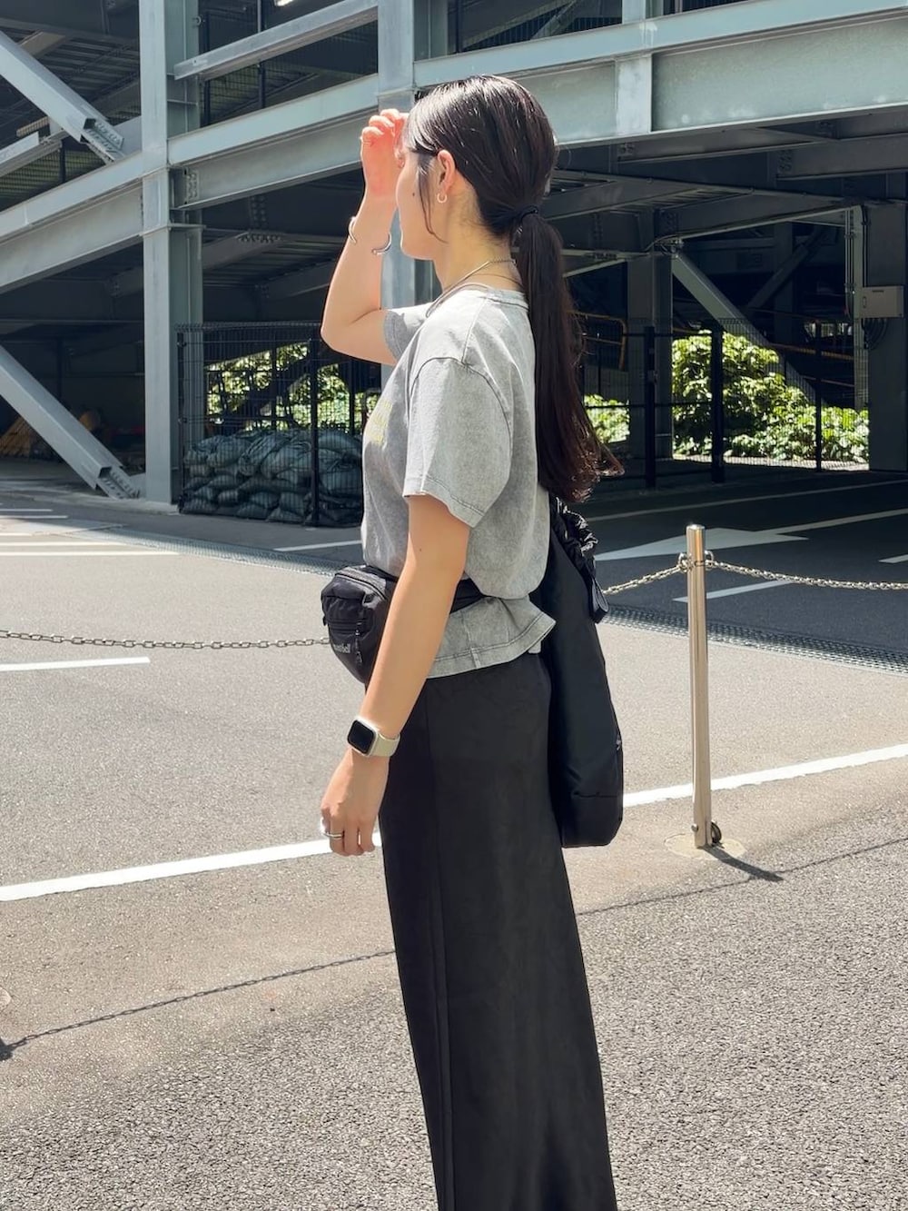 ブラック系のスカート、ブラック系のショルダーバッグ、グレー系のTシャツ/カットソーを着用したレディースの春コーディネートの5枚目の写真