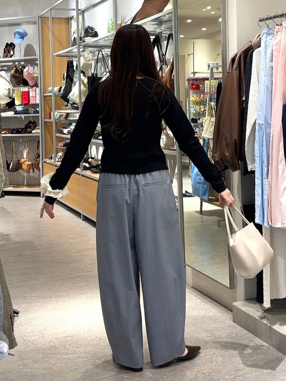グレー系のその他パンツ、ホワイト系のショルダーバッグ、ブラック系のカーディガン/ボレロを着用したレディースの春コーディネートの3枚目の写真