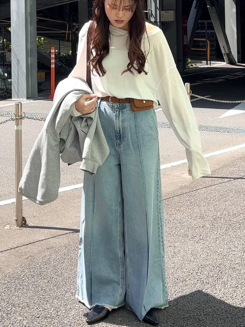 ホワイト系のTシャツ/カットソー、ブラウン系のトートバッグ、ブルー系のデニムパンツを着用したレディースの春コーディネートの7枚目の写真