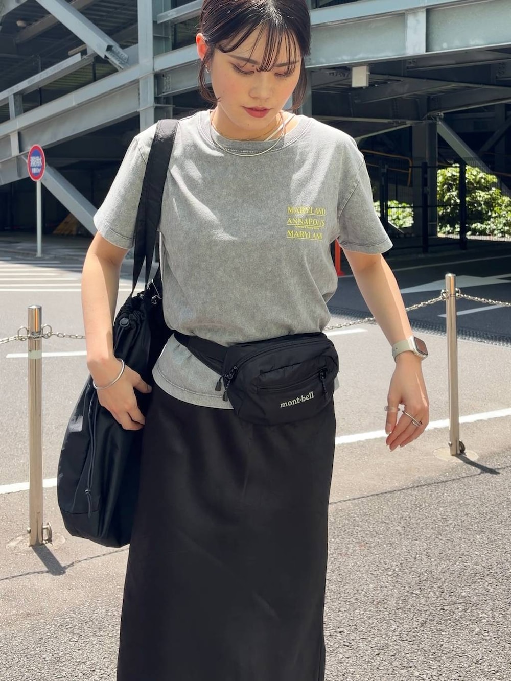 ブラック系のスカート、ブラック系のショルダーバッグ、グレー系のTシャツ/カットソーを着用したレディースの春コーディネートの6枚目の写真