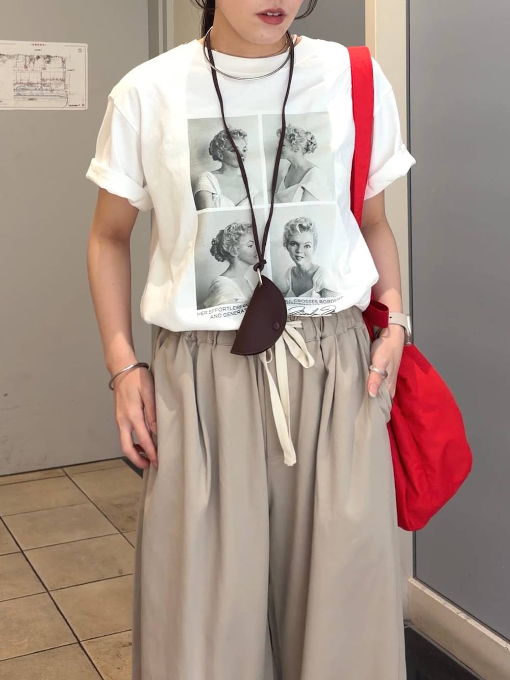 ベージュ系のデニムパンツ、レッド系のショルダーバッグ、ホワイト系のTシャツ/カットソーを着用したレディースの春コーディネートの2枚目の写真