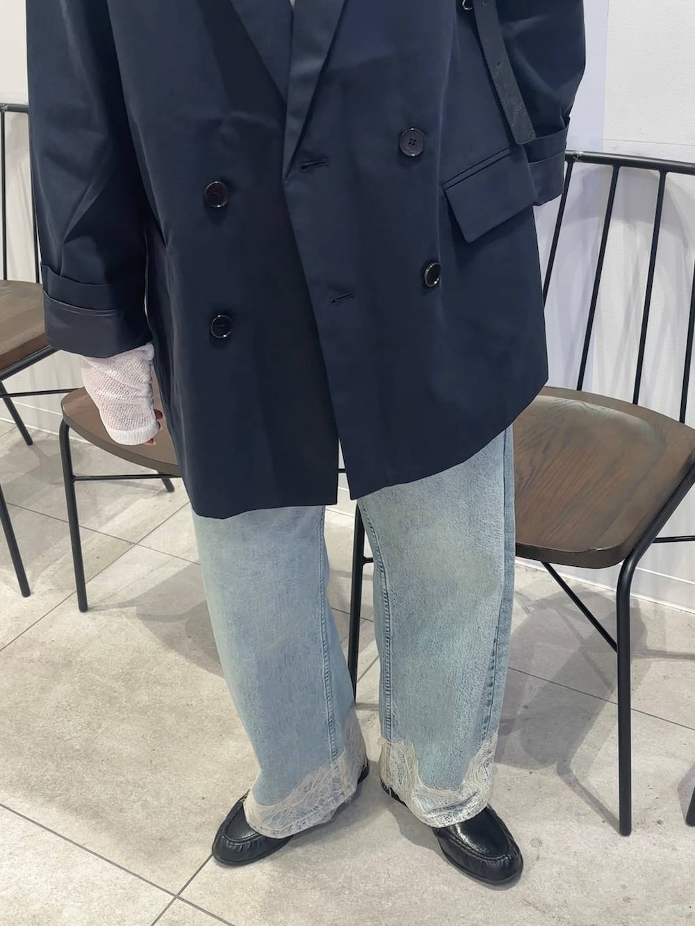 ブルー系のデニムパンツ、ブラック系のショルダーバッグ、ブラック系のローファーを着用したレディースの春コーディネートの3枚目の写真