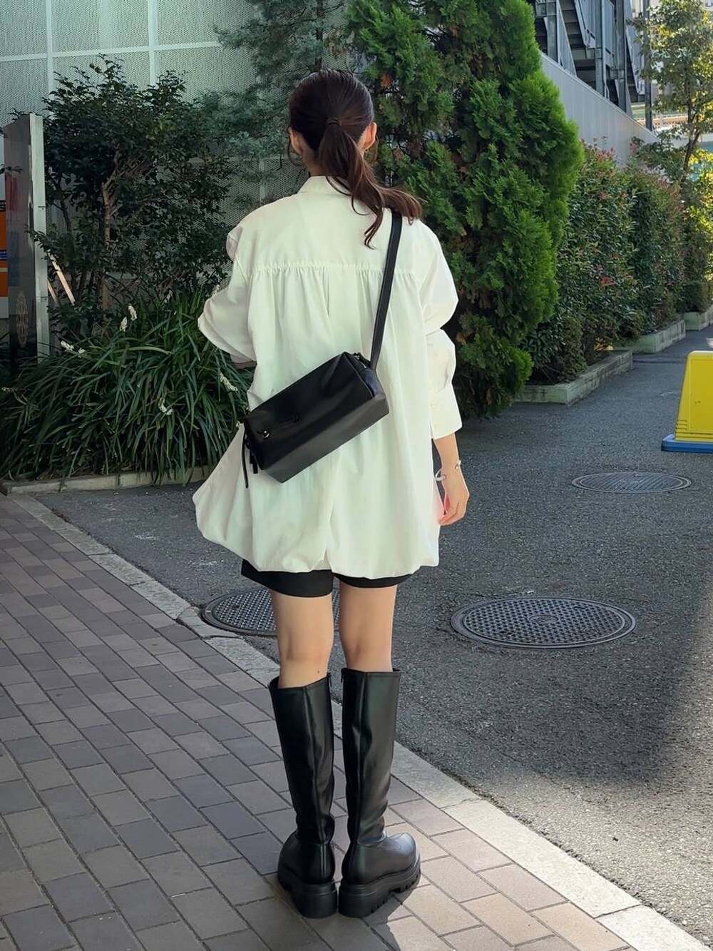 グレー系のその他パンツ、ブラック系のショルダーバッグ、ブラック系のブーツを着用したレディースの秋コーディネートの4枚目の写真
