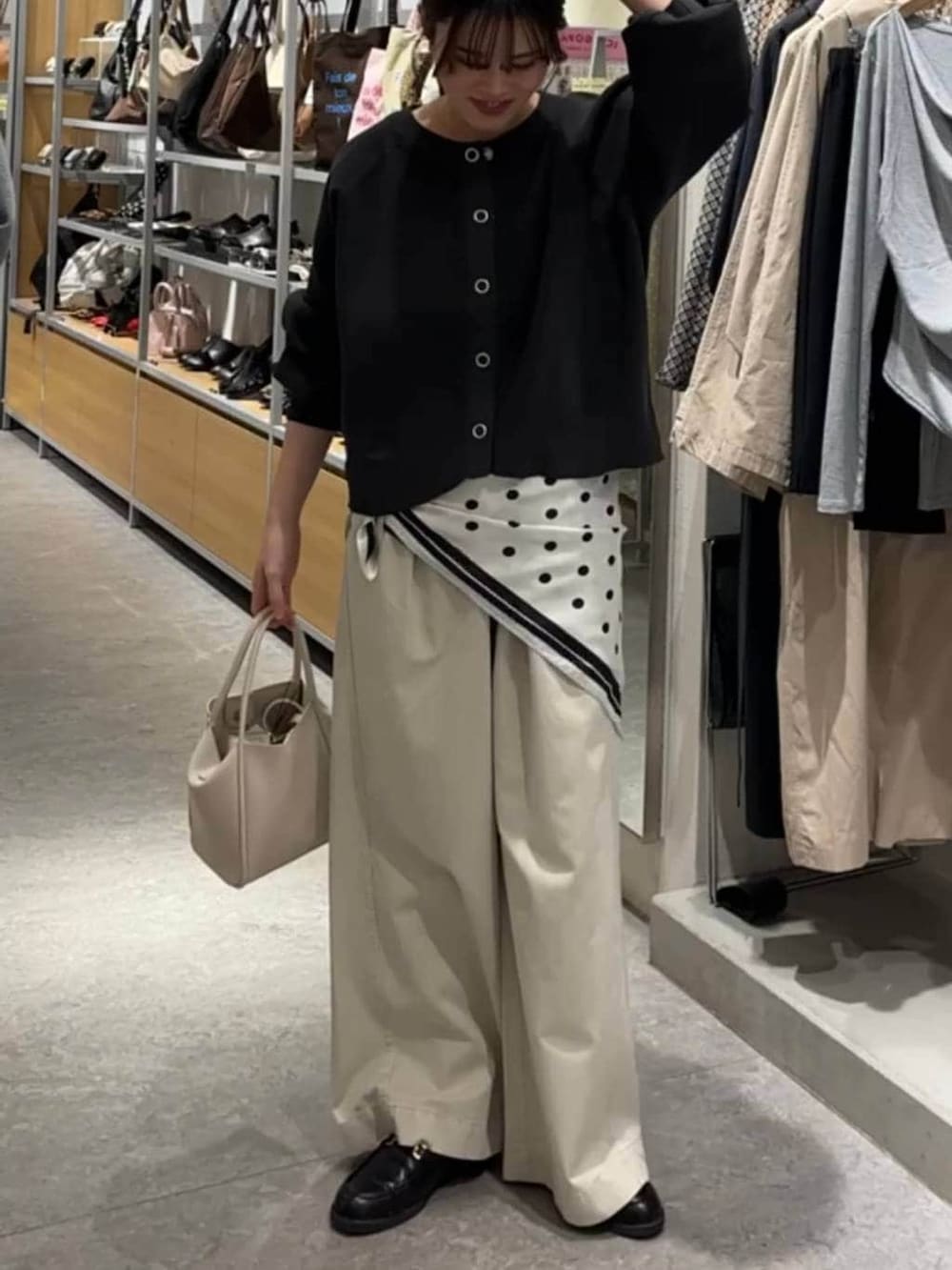 ホワイト系のショルダーバッグ、ホワイト系のデニムパンツ、グレー系のカーディガン/ボレロを着用したレディースの春コーディネートの3枚目の写真