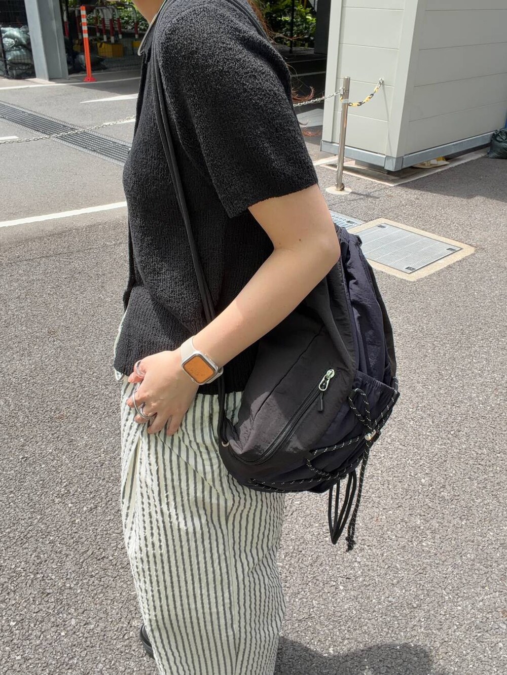 ブラック系のTシャツ/カットソー、ブラック系のバックパック/リュック、ホワイト系のその他パンツを着用したレディースの春コーディネートの3枚目の写真