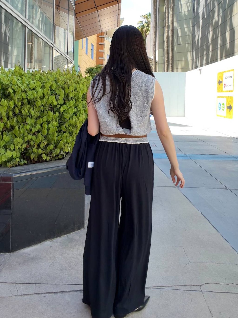 ブラック系のその他パンツ、ブルー系のテーラードジャケット、グレー系のベストを着用したレディースの春コーディネートの6枚目の写真