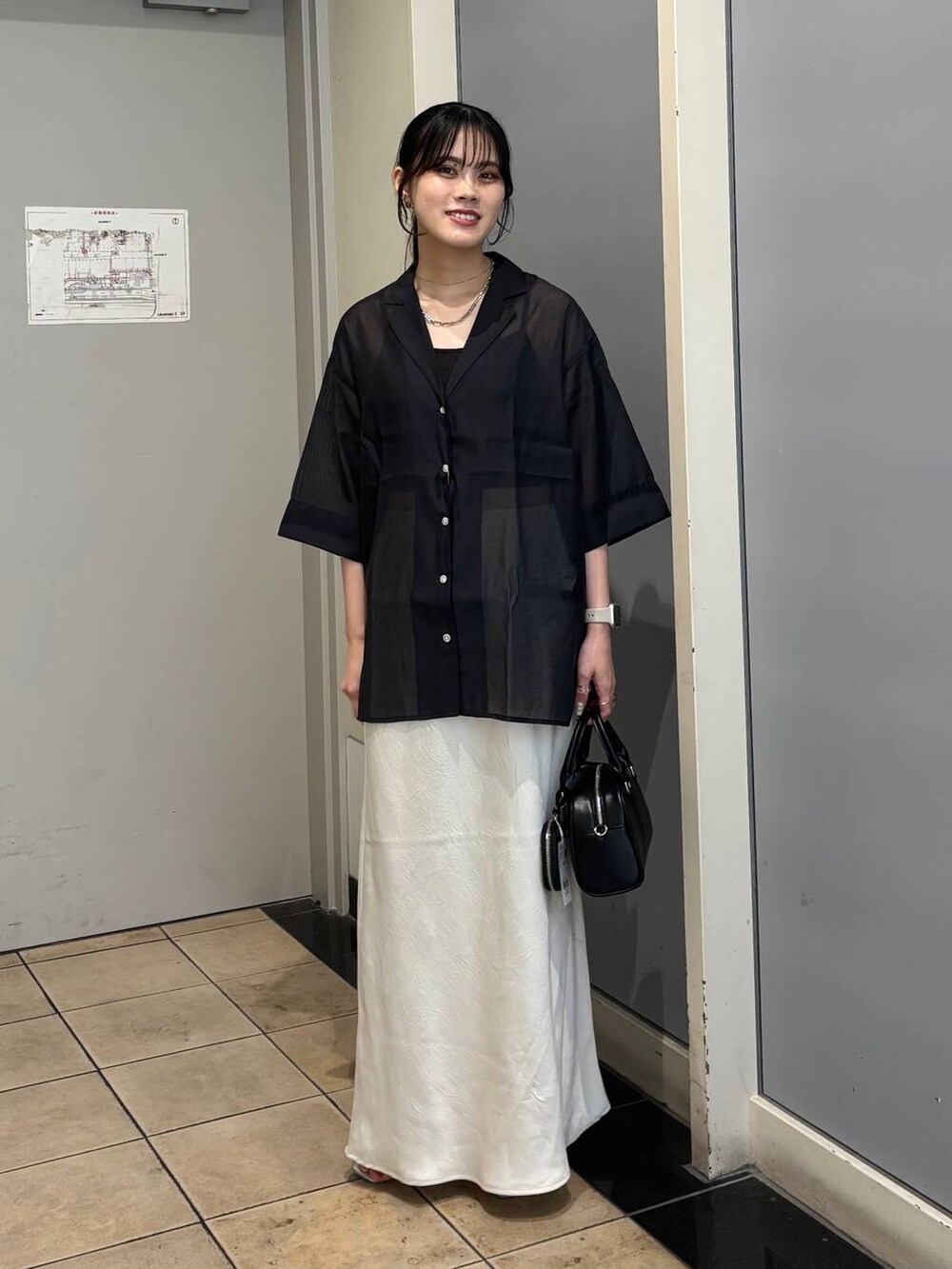 ホワイト系のスカート、シルバー系のサンダル、ブラック系のシャツ/ブラウスを着用したレディースの夏コーディネートの5枚目の写真