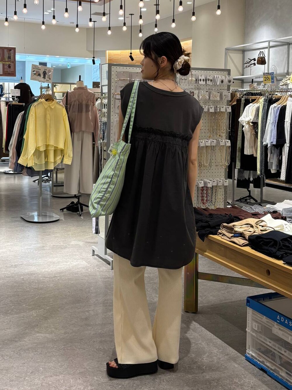 ブラック系のサンダル、その他のトートバッグ、ベージュ系のその他パンツを着用したレディースの夏コーディネートの3枚目の写真