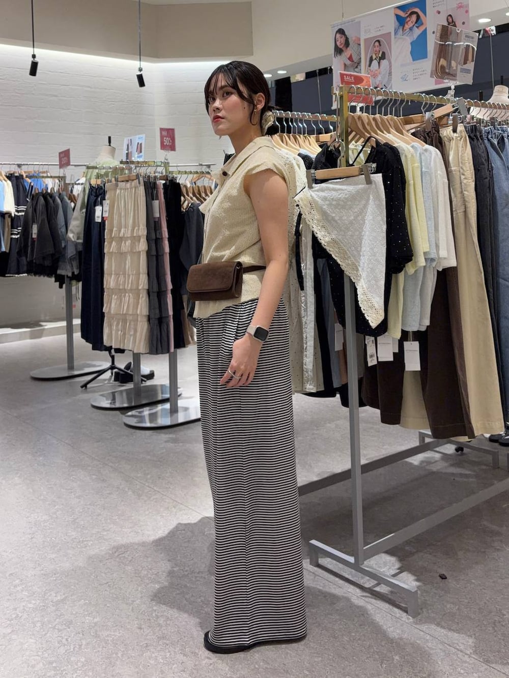 ホワイト系のベスト、ホワイト系のその他パンツ、ブラウン系のボディバッグ/ウエストポーチを着用したレディースの夏コーディネートの2枚目の写真