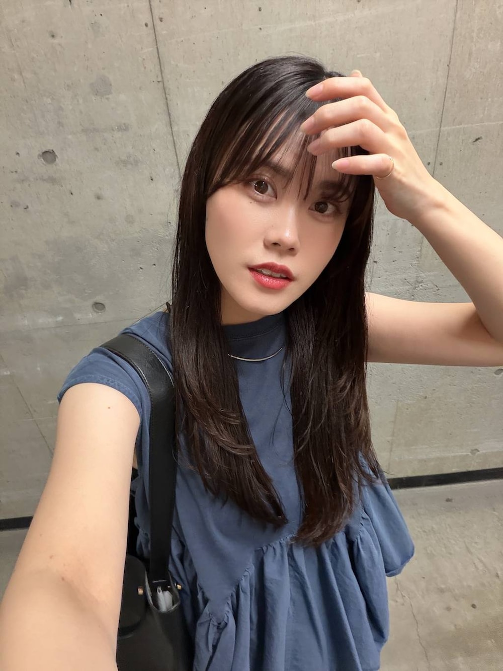 ブルー系のTシャツ/カットソー、ブラック系のスカート、ブラック系のトートバッグを着用したレディースの夏コーディネートの7枚目の写真