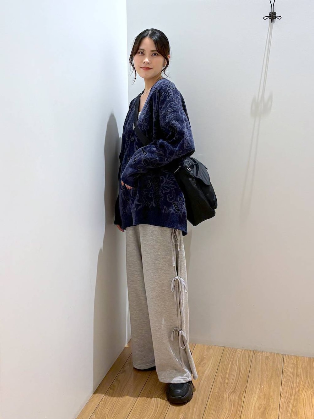 ブラック系のスニーカー、ブラック系のショルダーバッグ、グレー系のスウェットパンツを着用したレディースの秋コーディネートの3枚目の写真