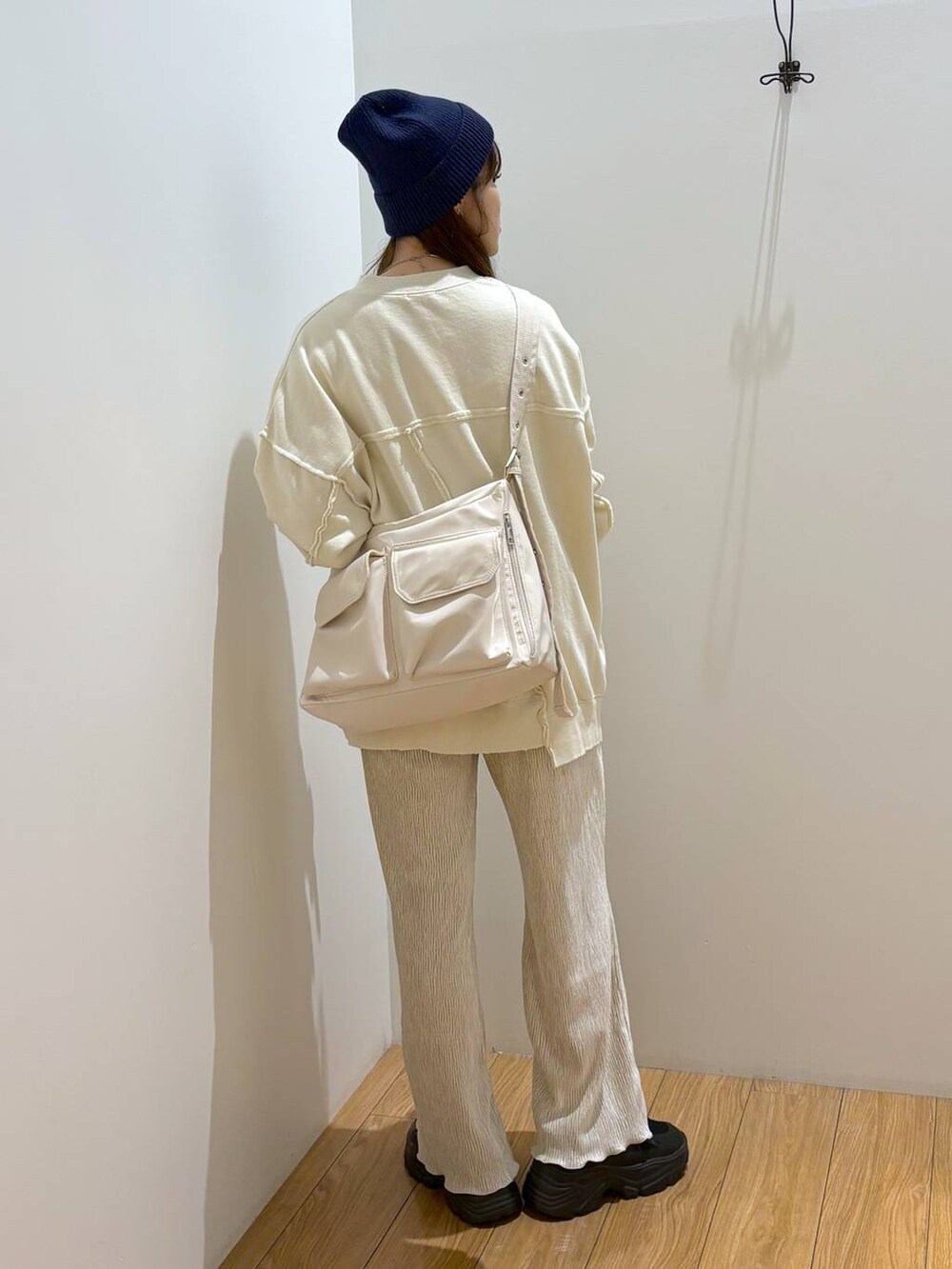 ホワイト系のその他パンツ、ブラック系のスニーカー、ホワイト系のショルダーバッグを着用したレディースの冬コーディネートの4枚目の写真