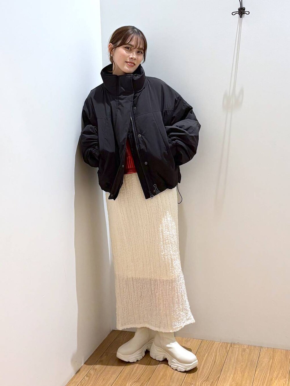 レッド系のニット/セーター、ブラック系のその他アウター、ホワイト系のブーツを着用したレディースの秋コーディネートの5枚目の写真