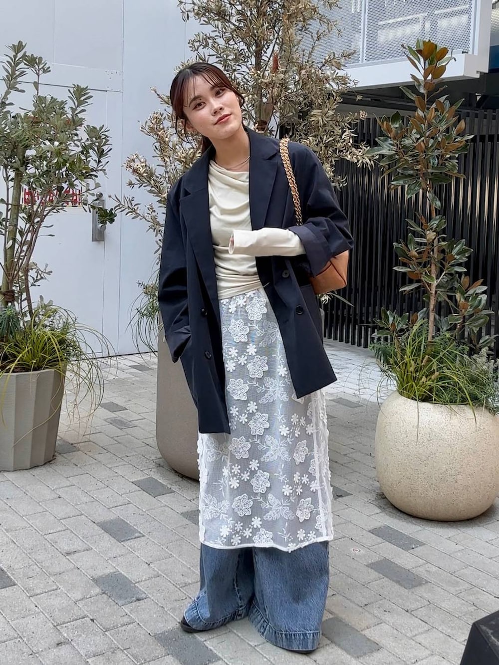 ブラック系のローファー、ベージュ系のショルダーバッグ、ブルー系のデニムパンツを着用したレディースの冬コーディネートの7枚目の写真