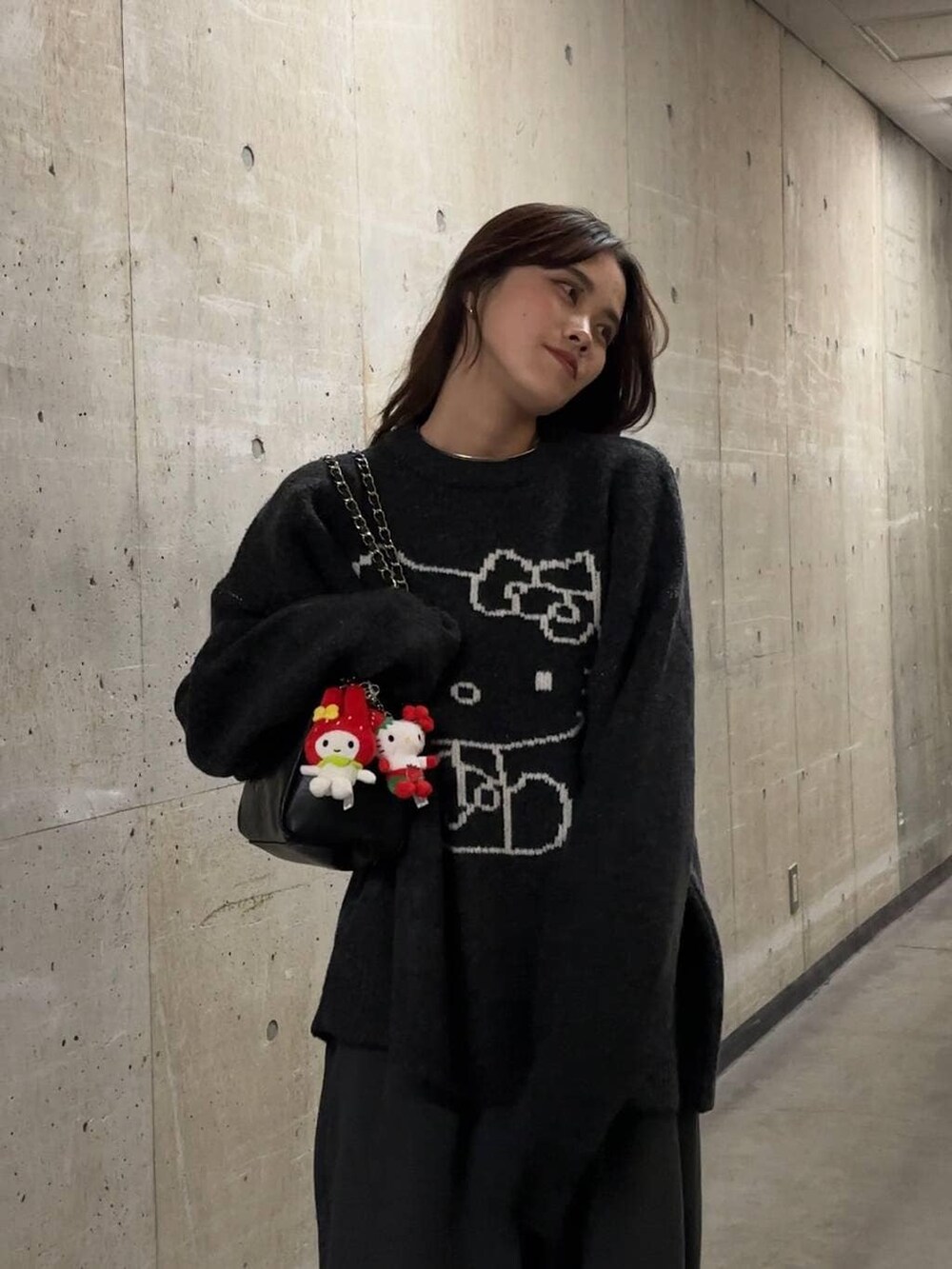 ブラック系のショルダーバッグ、グレー系のニット/セーター、シルバー系のチョーカーを着用したレディースの秋コーディネートの5枚目の写真