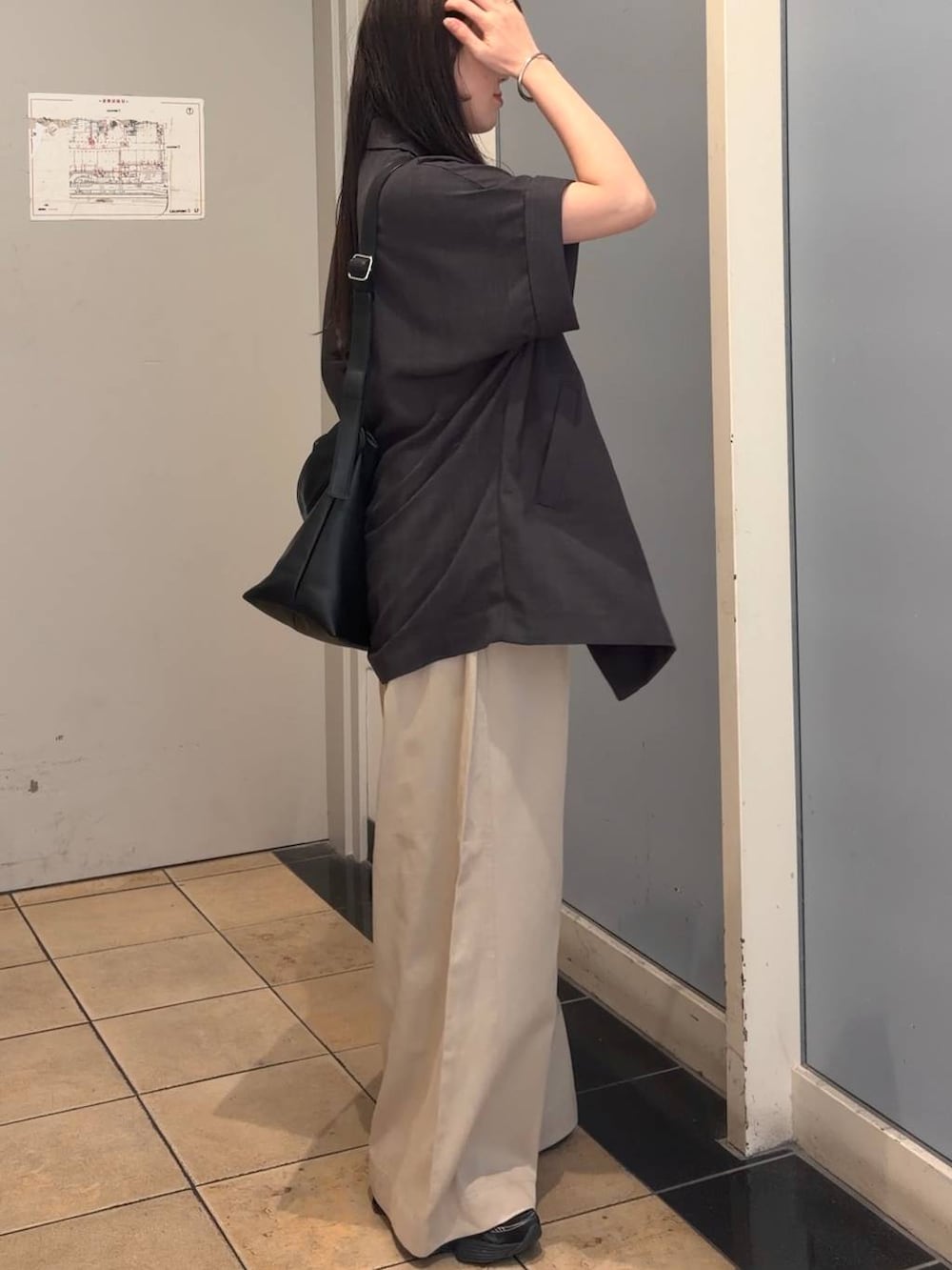 ベージュ系のデニムパンツ、グレー系のテーラードジャケット、ブラック系のショルダーバッグを着用したレディースの夏コーディネートの2枚目の写真