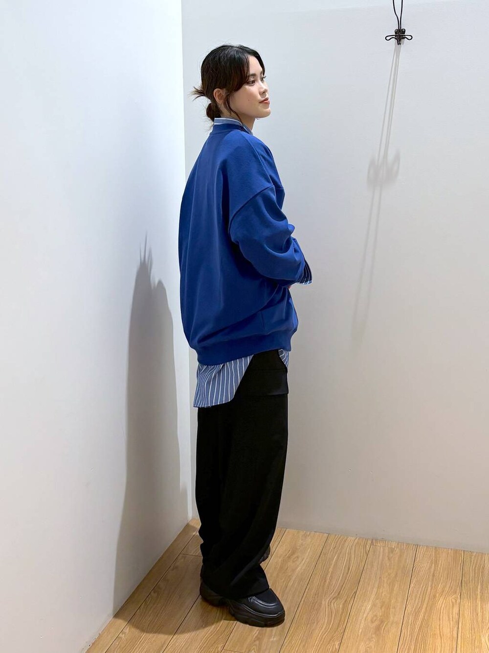 ブルー系のシャツ/ブラウス、ブラック系のスラックス、ブラック系のスニーカーを着用したレディースの秋コーディネートの3枚目の写真