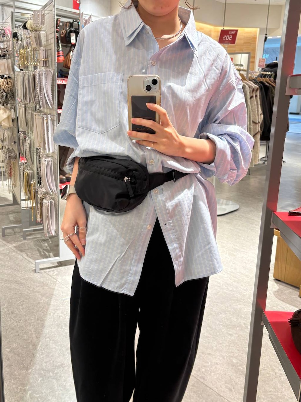 ブラック系のスウェットパンツ、ブラック系のボディバッグ/ウエストポーチ、ブルー系のシャツ/ブラウスを着用したレディースの冬コーディネートの3枚目の写真