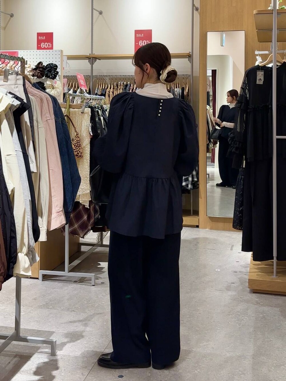 ブラック系のショルダーバッグ、ブラック系のローファー、ホワイト系のTシャツ/カットソーを着用したレディースの冬コーディネートの6枚目の写真