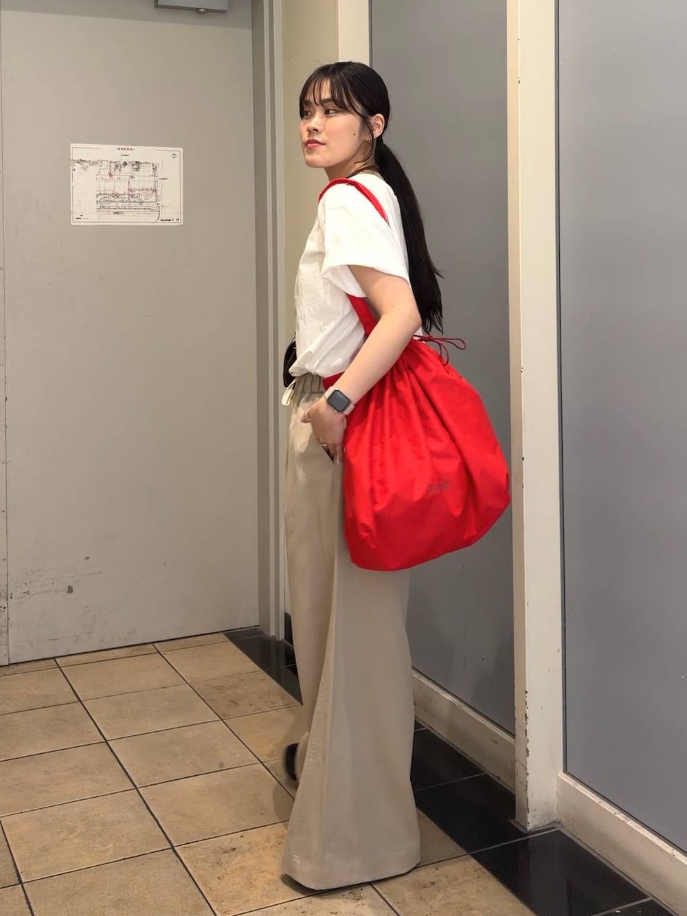ベージュ系のデニムパンツ、レッド系のショルダーバッグ、ホワイト系のTシャツ/カットソーを着用したレディースの春コーディネートの3枚目の写真