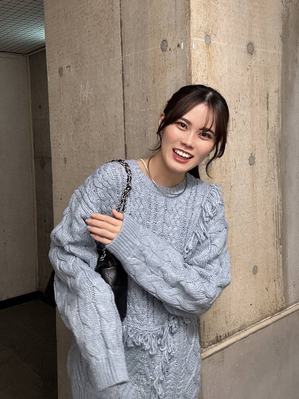 ブルー系のニット/セーター、ブラック系のショルダーバッグ、シルバー系のチョーカーを着用したレディースの秋コーディネートの2枚目の写真