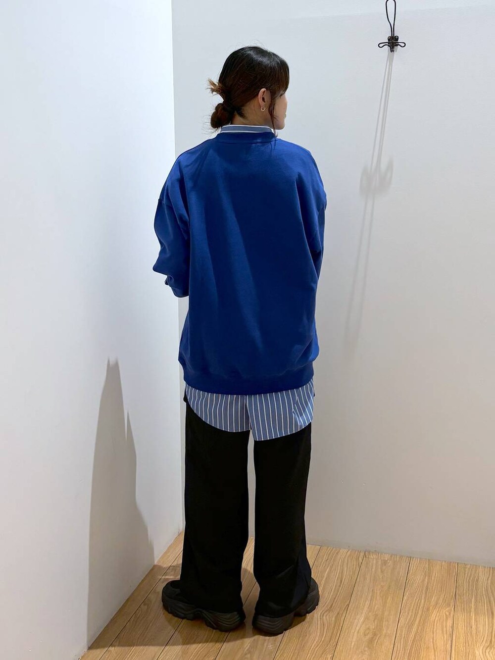 ブルー系のシャツ/ブラウス、ブラック系のスラックス、ブラック系のスニーカーを着用したレディースの秋コーディネートの4枚目の写真