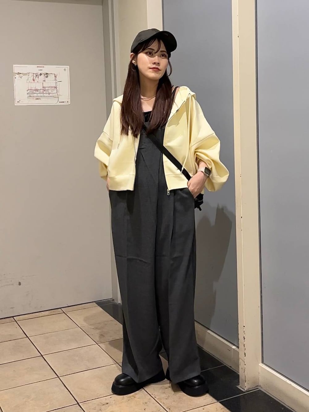 グレー系のサロペット/オーバーオール、ブラック系のショルダーバッグ、ブラック系のキャミソールを着用したレディースの秋コーディネートの7枚目の写真