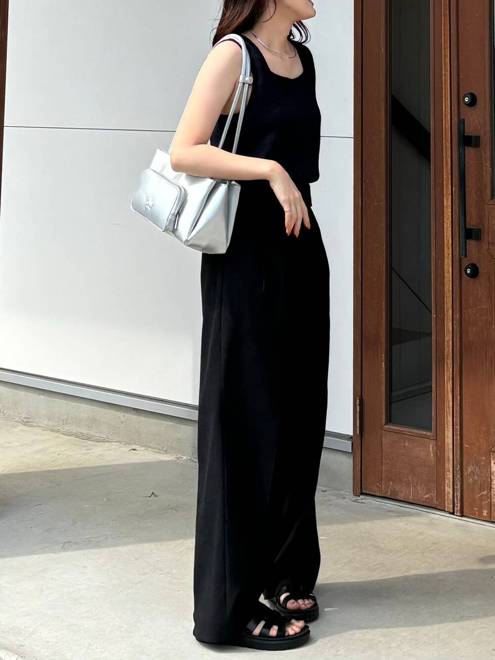 ブラック系のタンクトップ、ブラック系のスニーカー、ブラック系のスラックスを着用したレディースの夏コーディネートの2枚目の写真