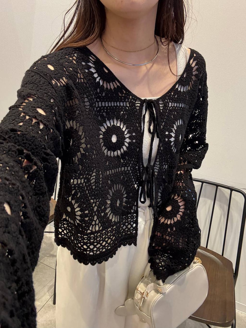 シルバー系のタンクトップ、ホワイト系のボストンバッグ、ホワイト系のその他パンツを着用したレディースの春コーディネートの2枚目の写真