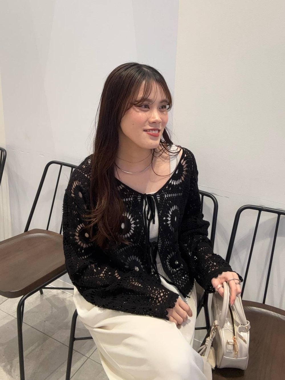 シルバー系のタンクトップ、ホワイト系のボストンバッグ、ホワイト系のその他パンツを着用したレディースの春コーディネートの5枚目の写真