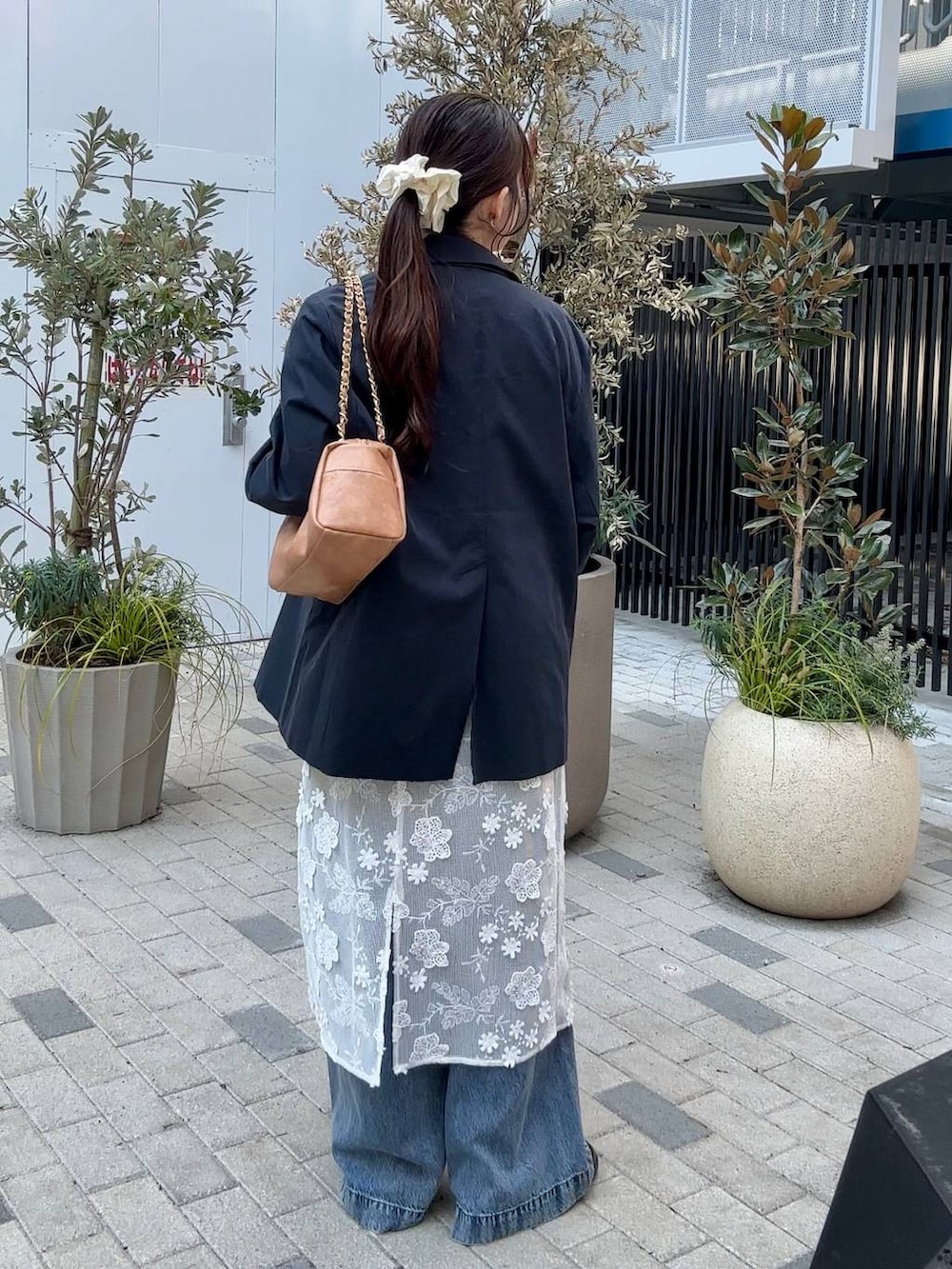 ブラック系のローファー、ベージュ系のショルダーバッグ、ブルー系のデニムパンツを着用したレディースの冬コーディネートの6枚目の写真