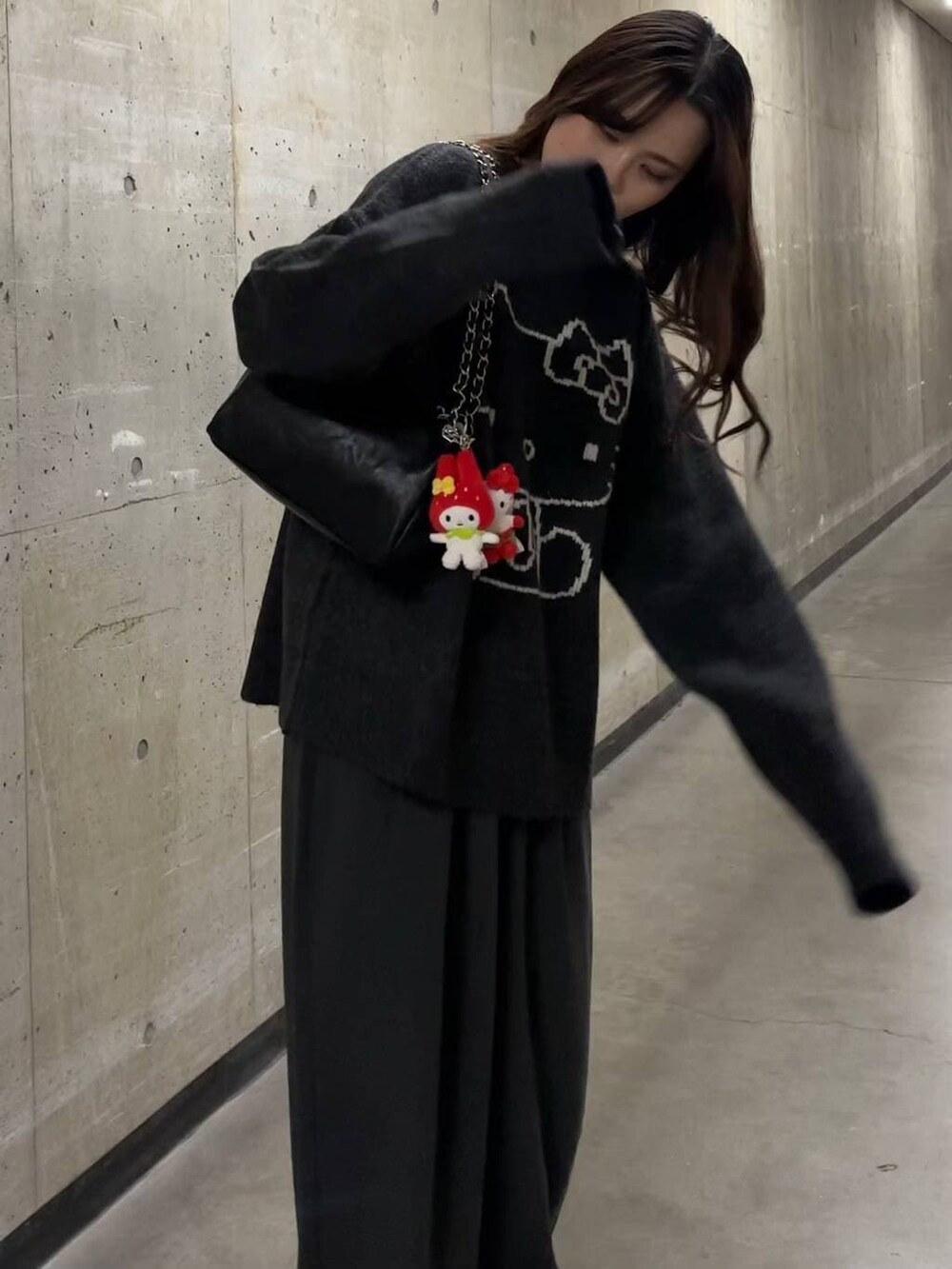 ブラック系のショルダーバッグ、グレー系のニット/セーター、シルバー系のチョーカーを着用したレディースの秋コーディネートの2枚目の写真