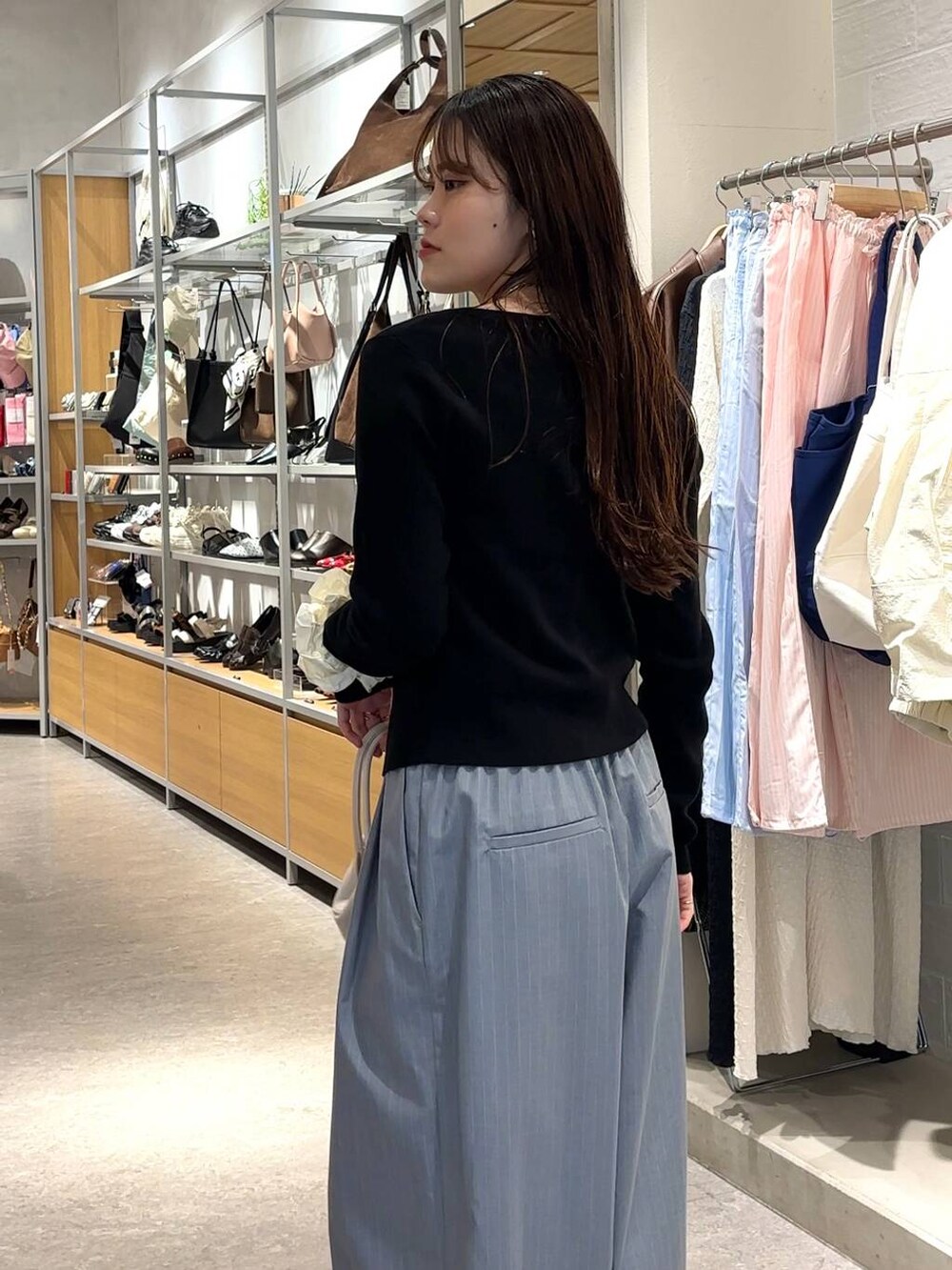 グレー系のその他パンツ、ホワイト系のショルダーバッグ、ブラック系のカーディガン/ボレロを着用したレディースの春コーディネートの5枚目の写真