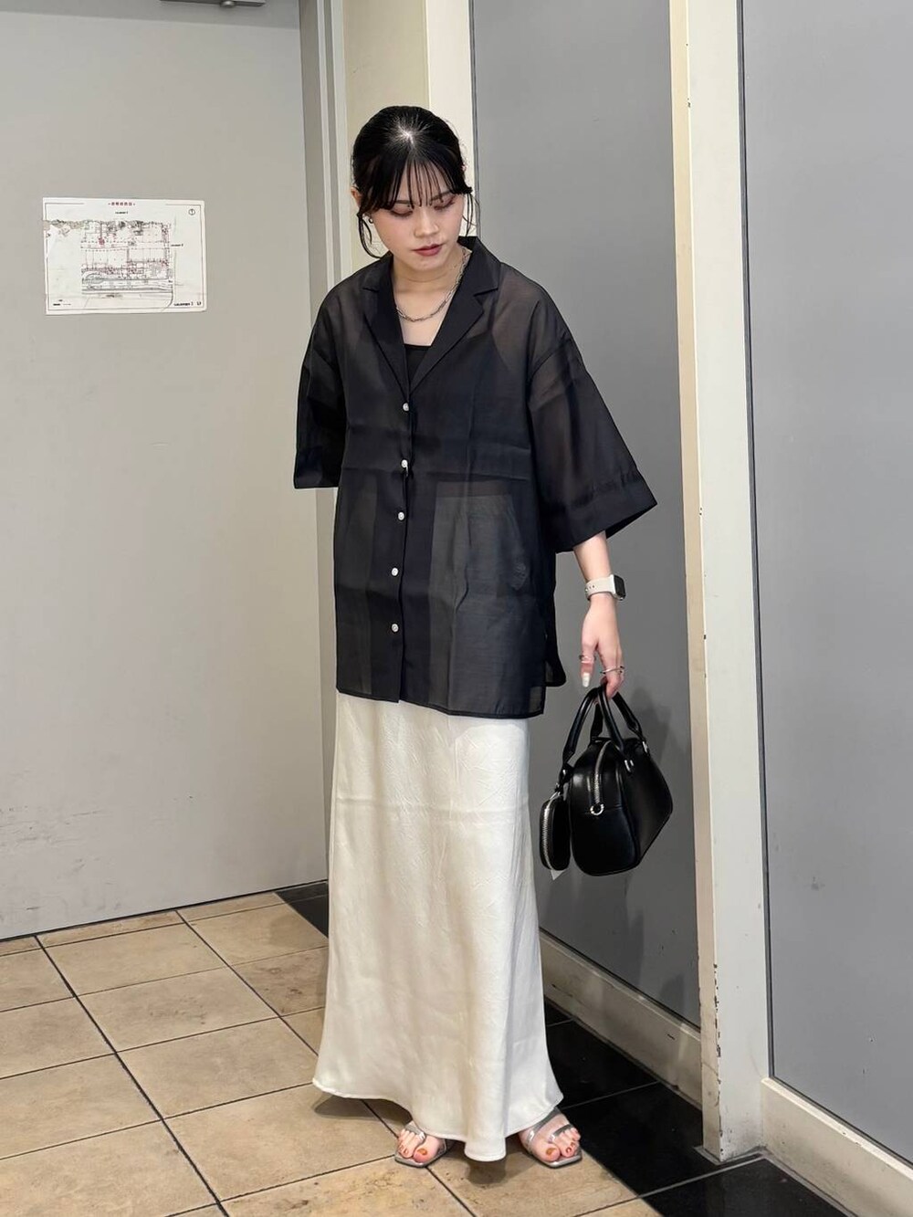 ホワイト系のスカート、シルバー系のサンダル、ブラック系のシャツ/ブラウスを着用したレディースの夏コーディネートの2枚目の写真