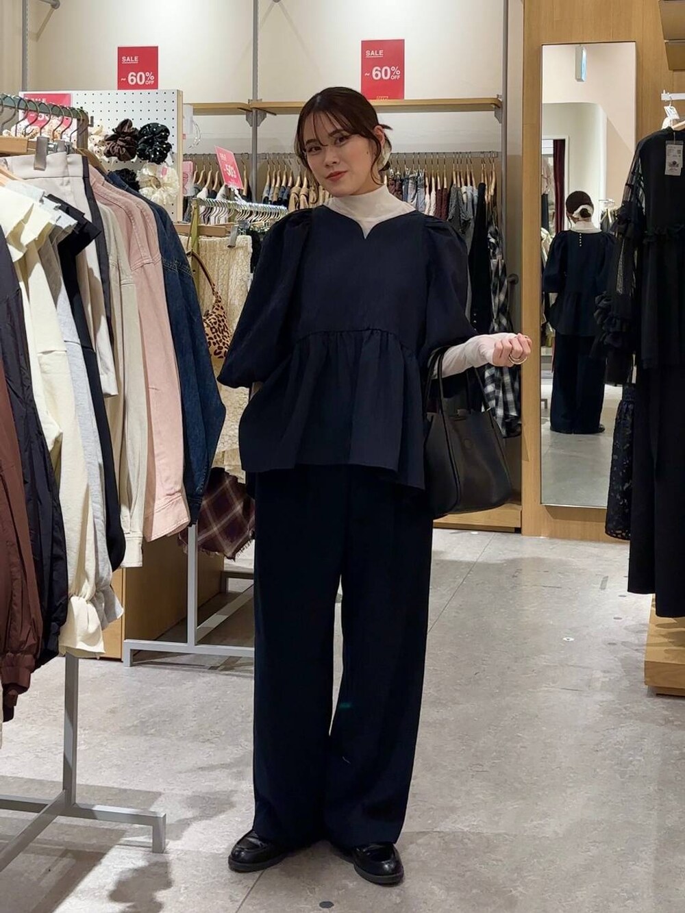 ブラック系のショルダーバッグ、ブラック系のローファー、ホワイト系のTシャツ/カットソーを着用したレディースの冬コーディネートの4枚目の写真