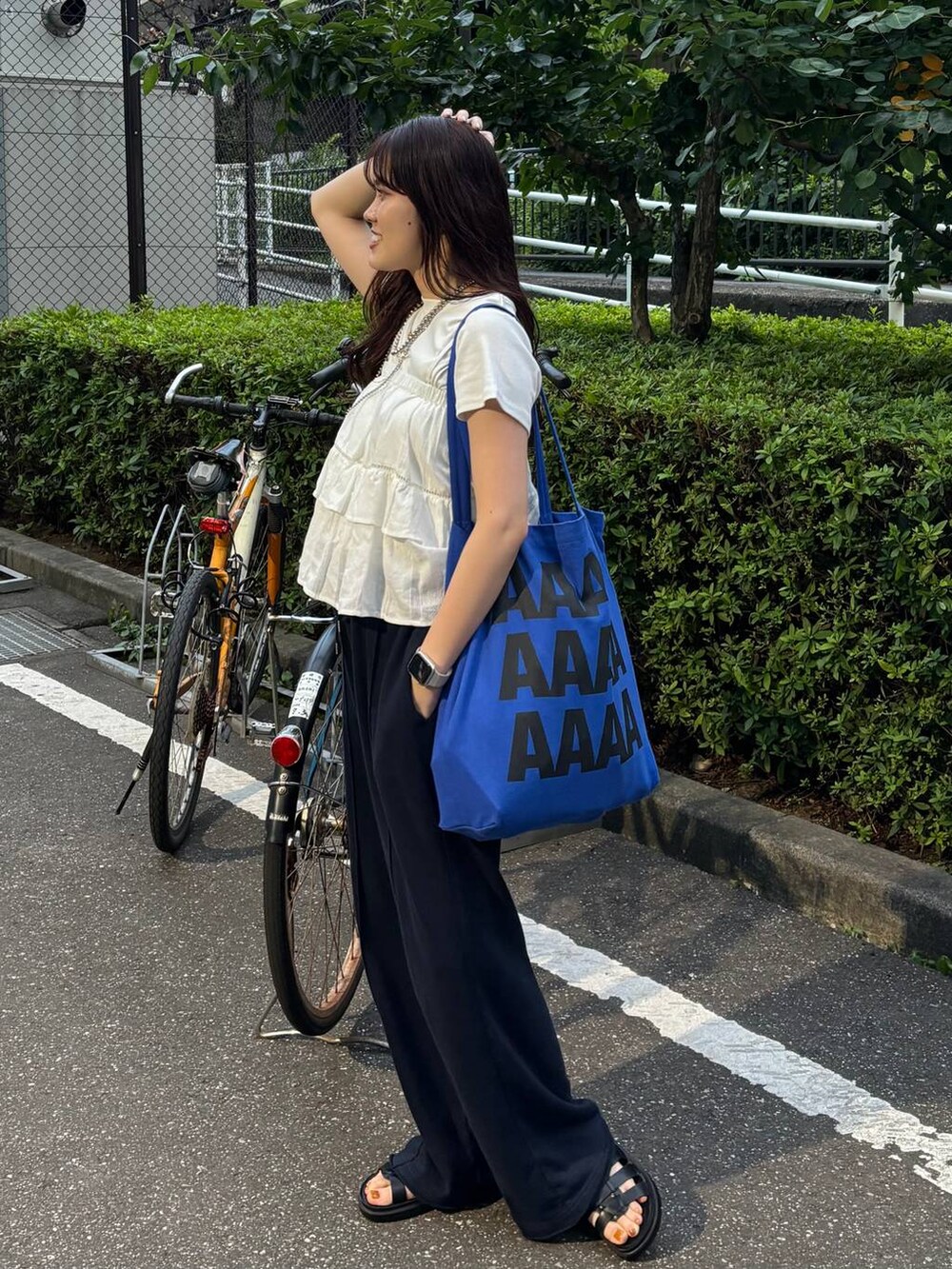 ホワイト系のTシャツ/カットソー、ブラック系のサンダル、ホワイト系のキャミソールを着用したレディースの夏コーディネートの3枚目の写真