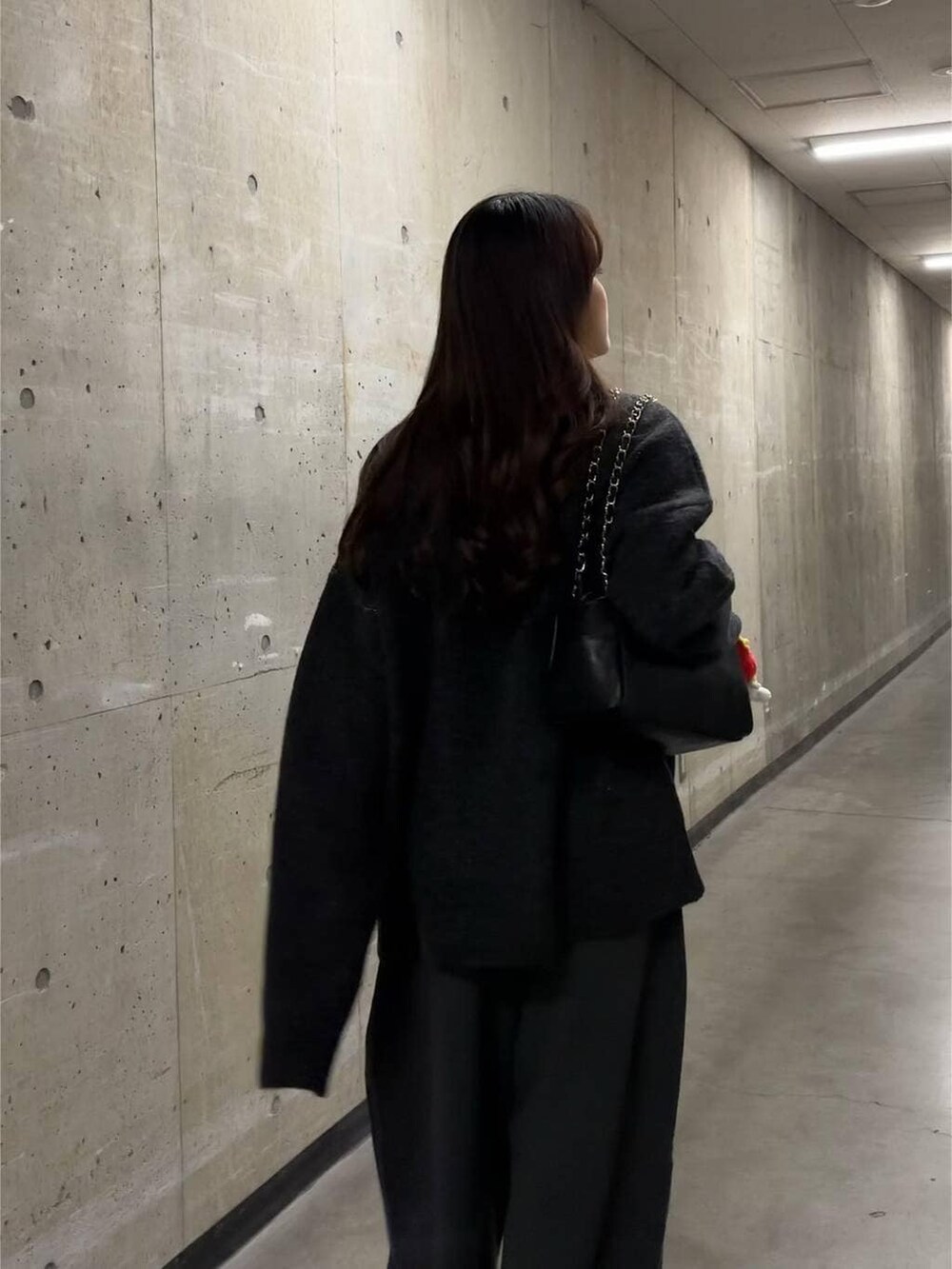 ブラック系のショルダーバッグ、グレー系のニット/セーター、シルバー系のチョーカーを着用したレディースの秋コーディネートの3枚目の写真