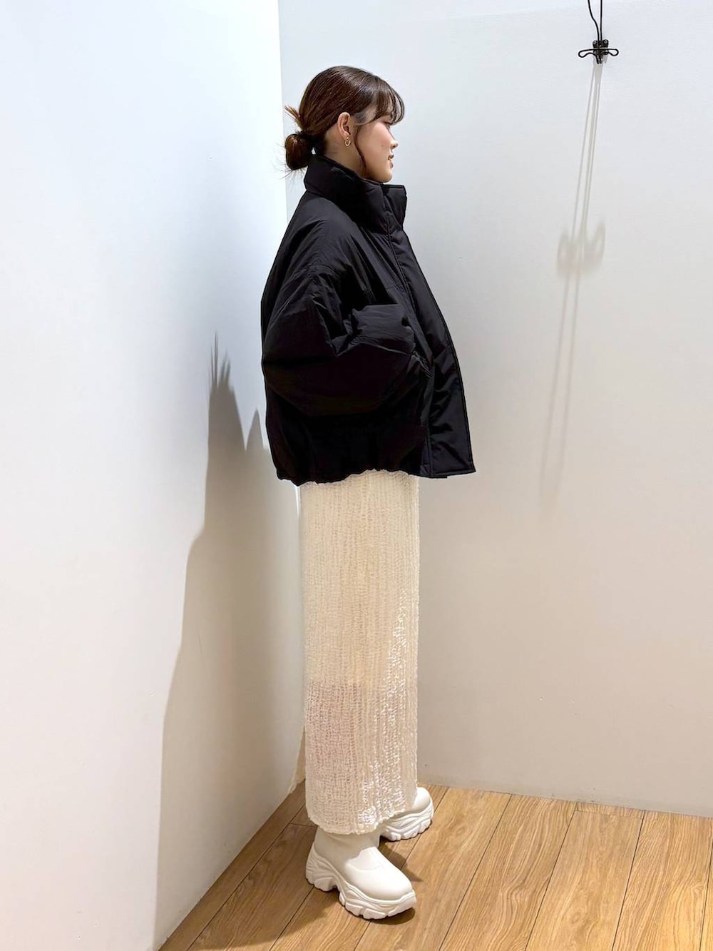 レッド系のニット/セーター、ブラック系のその他アウター、ホワイト系のブーツを着用したレディースの秋コーディネートの3枚目の写真